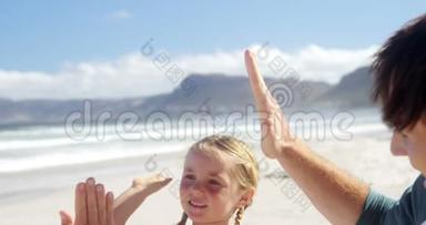 <strong>父亲和女儿在海滩</strong>上互相击掌